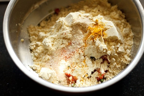 gram flour, turmeric powder, red chili powder, asafoetida and salt added to the bowl for making batter for besan toast. 