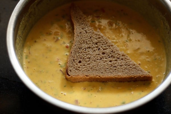 dipping bread piece in the prepared batter. 