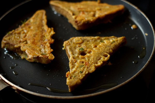 frying besan bread toast till evenly cooked and browned from both sides. 