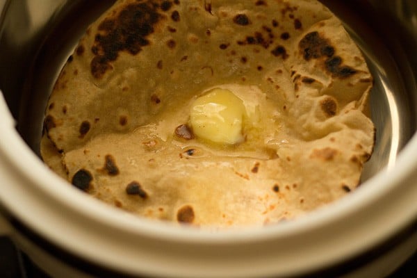 butter spread on top of butter naans staked in a casserole. 