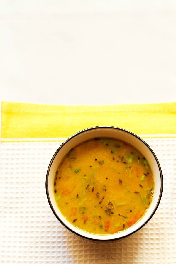 Gujarati dal in a black rimmed bowl on a white and yellow linen