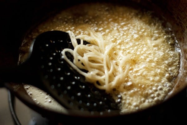 noodles being added to oil