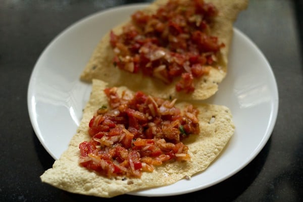 prepared masala topping added on fried papad pieces. 