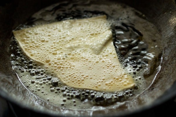 frying papad piece in hot oil till crisp. 