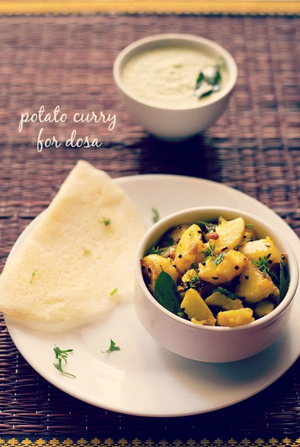 potato masala served in a bowl with a dosa and a bowl of coconut chutney kept on the top side and text layovers.