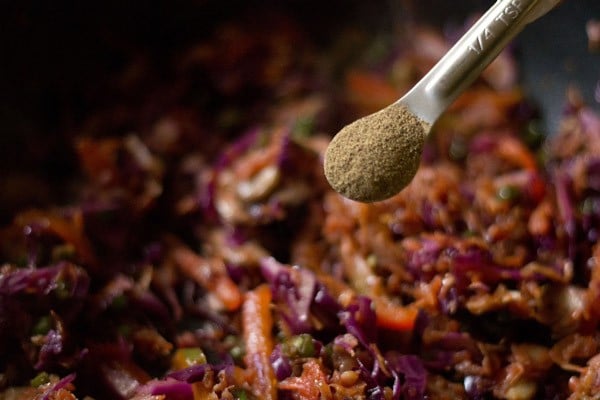 black pepper being added to veggie stir fry