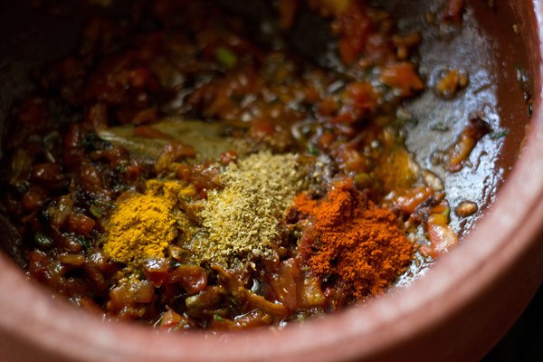 adding spice powders to make vegetable handi recipe