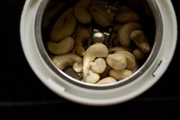 drained cashews added to a blender jar. 