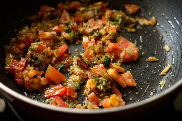 adding chopped  tomatoes to onion mixture