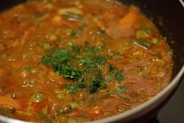 garnishing veg kolhapuri with chopped coriander leaves