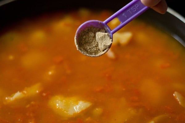 adding dried mango powder to the pan. 