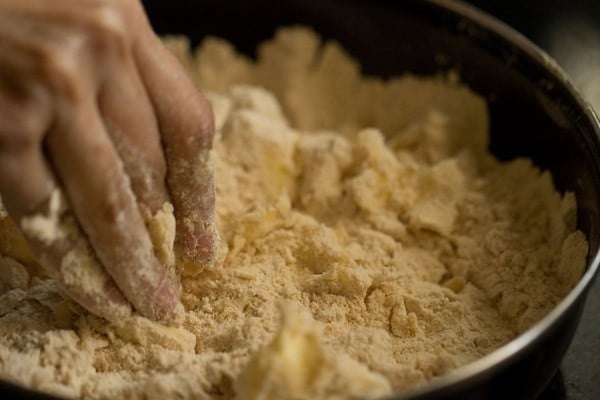hand mixing chopped butter in with flour