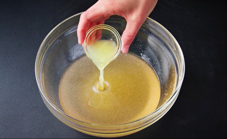 lemon juice being added to wet mixture for healthy eggless chocolate cake