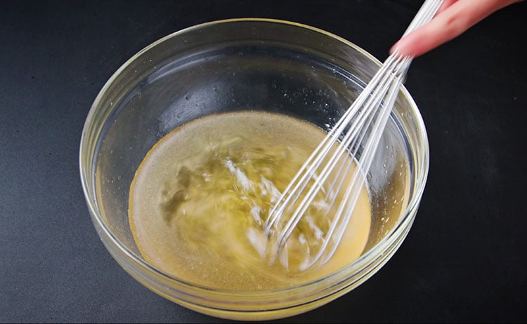 mixing wet chocolate cake ingredients again with a whisk