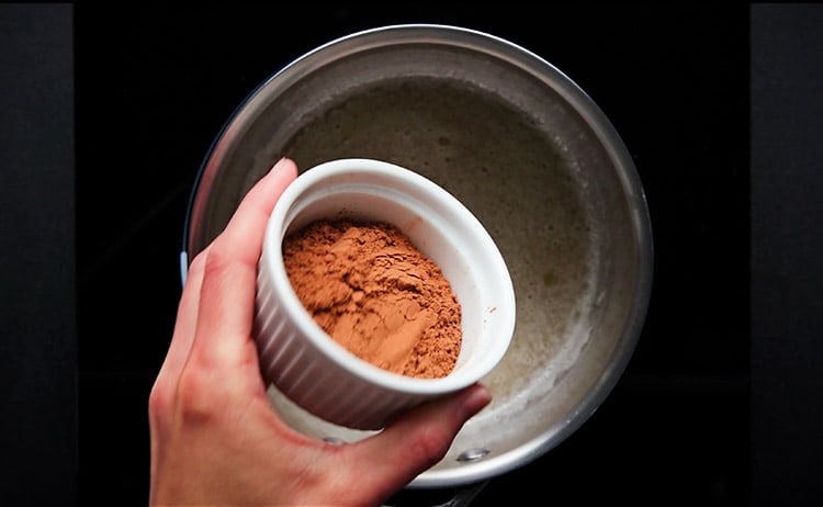 adding cocoa powder to almond milk mixture