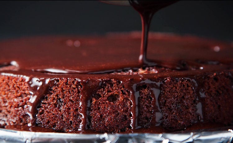 pouring the icing on the vegan chocolate cake