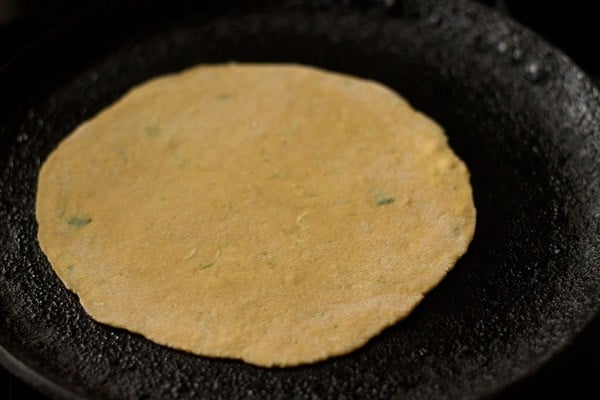 rolled dough placed on a hot tawa/skillet