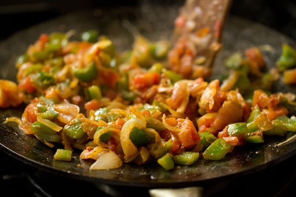 stir and mixing spices with paneer khurchan masala