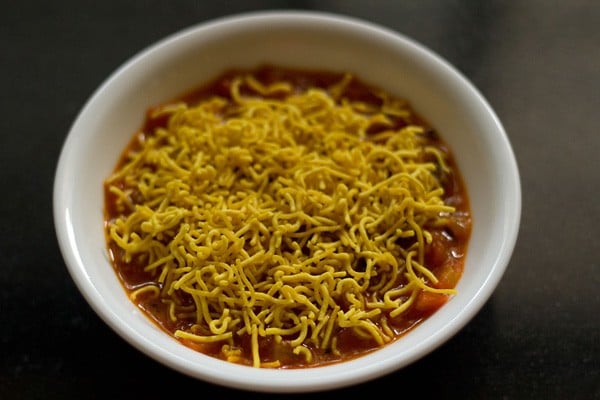 tomato curry topped with sev. 