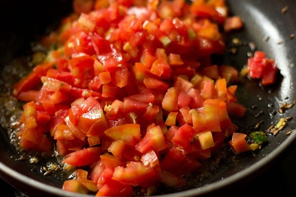 chopped tomatoes added to the pan for making sev tamatar sabji. 