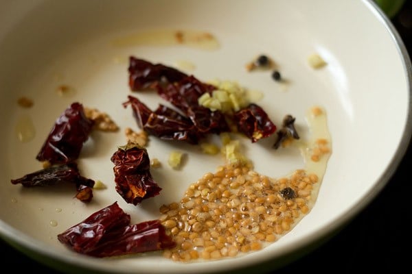 dried red chilies, cloves, black peppercorns and chopped ginger added to the pan. 