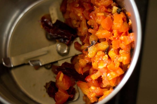 cooked tomato mixture with spices added to a blender jar. 