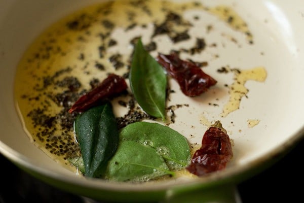 curry leaves, fenugreek seeds, asafoetida and dried red chili added to the pan. 