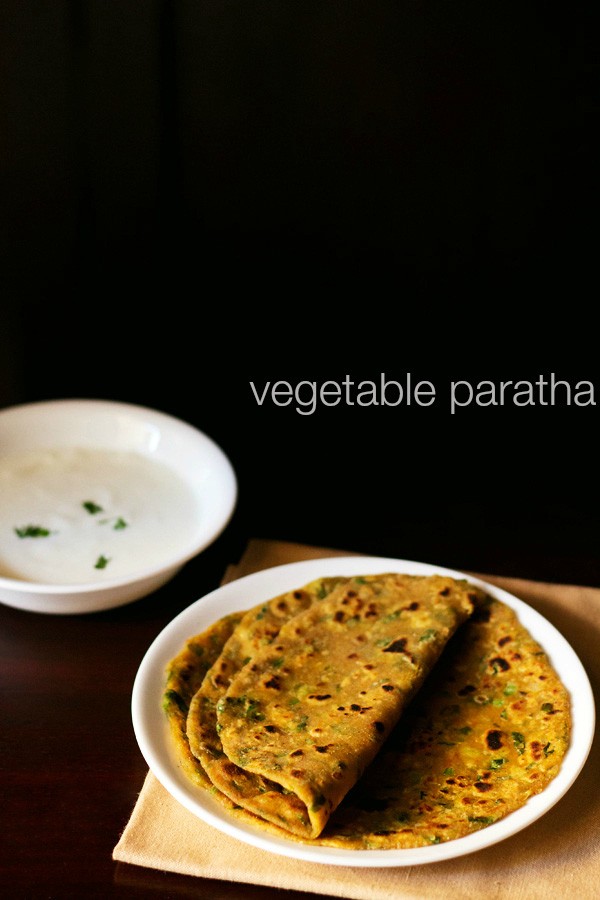 mix veg paratha served on a white plate with a bowl of curd kept on the top left side and text layover.