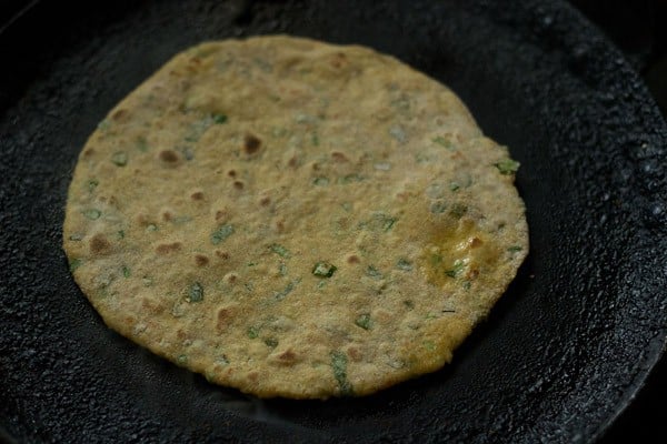 cooking mix veg paratha on a tawa