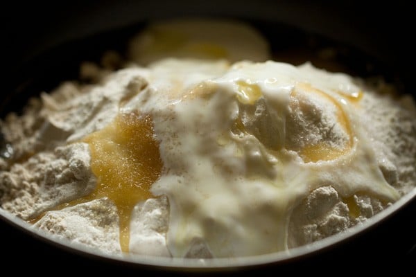 adding curd and oil in flour mixture