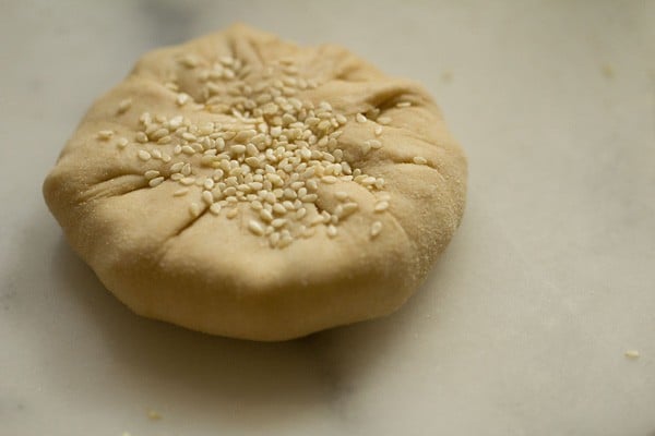 sesame seeds on the stuffed dough ball
