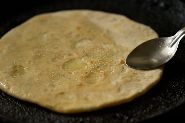 ghee on flipped aloo kulcha