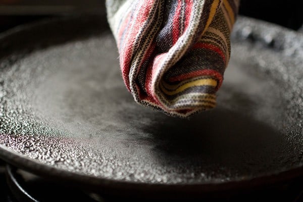 wiping tawa to get rid of burnt flour particles 