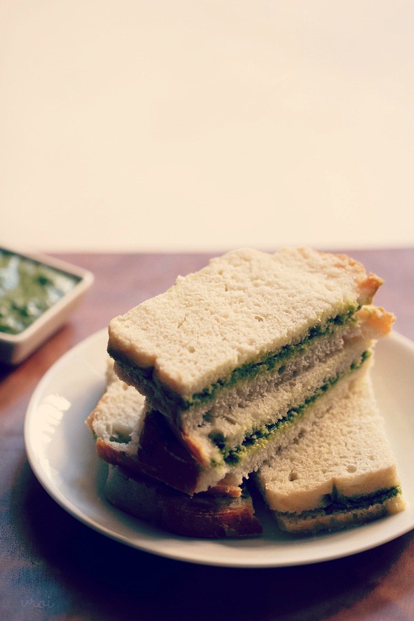 chutney sandwich slices served on top of each other on a white ceramic plate. 