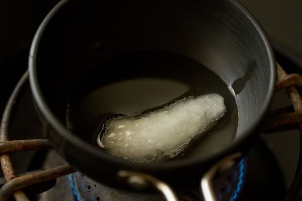 heating coconut oil in a small pan for tempering red coconut chutney. 