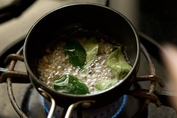 hojas de curry y chalotes picados añadidos al aceite de coco caliente. 
