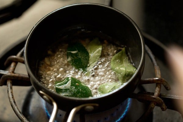 curry leaves and chopped shallots added to hot coconut oil. 