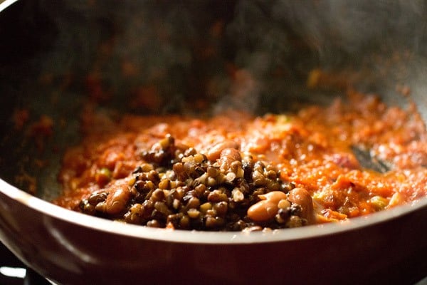 cooked urad dal and rajma added to the tomato puree. 