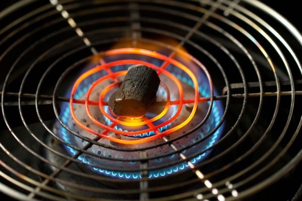 charcoal placed on top of a wired rack on a gas-stove burner. 