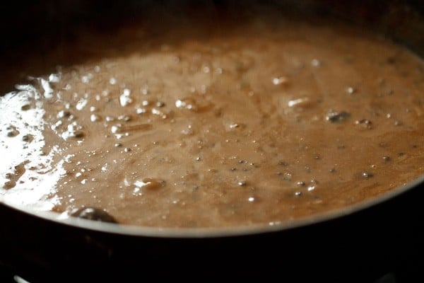 mixing cream with the dal makhani. 