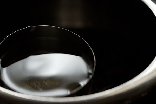 pouring water in the pressure cooker. 