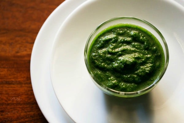 green chutney or hari chatni served in a bowl kept on a white plate. 