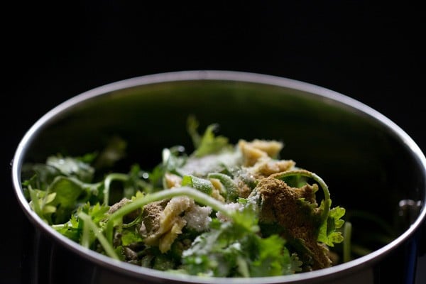 chopped coriander leaves and other ingredients added in a blender jar for hari chatni.