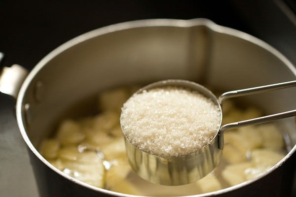 chopped pineapple. water and sugar added in a pan. 