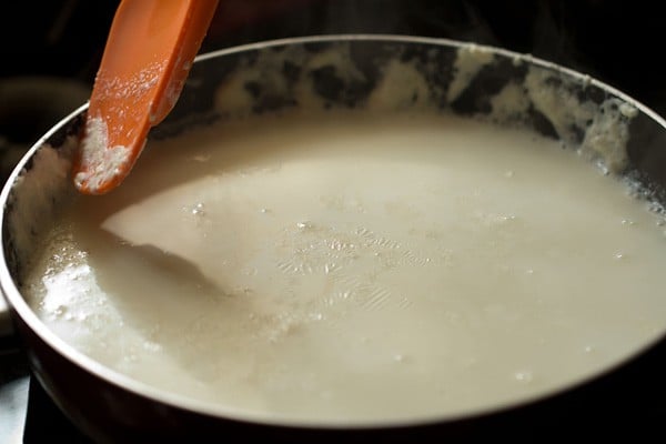 collecting malai or clotted cream at sides of pan