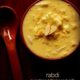 top shot of rabdi in red bowl with nuts and a light sprinkle of saffron powder from top with text layovers