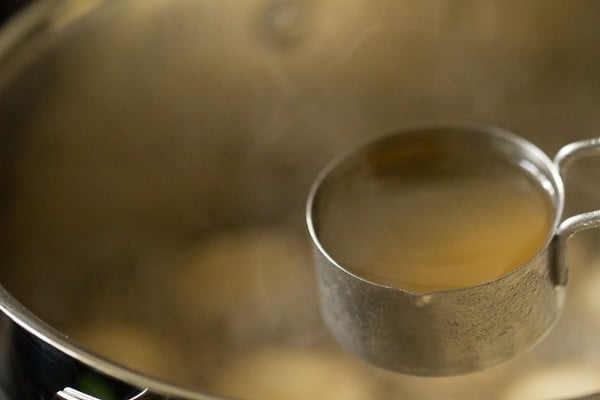 adding the remaining sugar syrup to the pot with the rasgulla