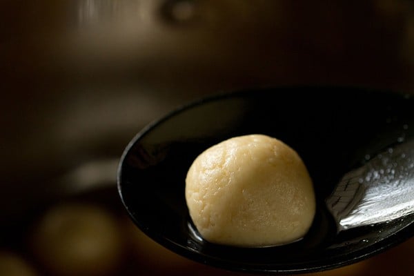 black spoon with a Bengali rasgulla