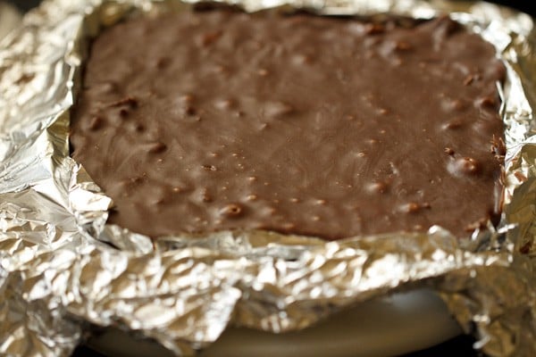 The chocolate fudge removed from the tin and placed on a chopping board. 