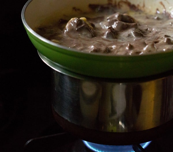 The pan containing the milk chocolate, condensed milk and butter kept on top of the pot containing hot water.